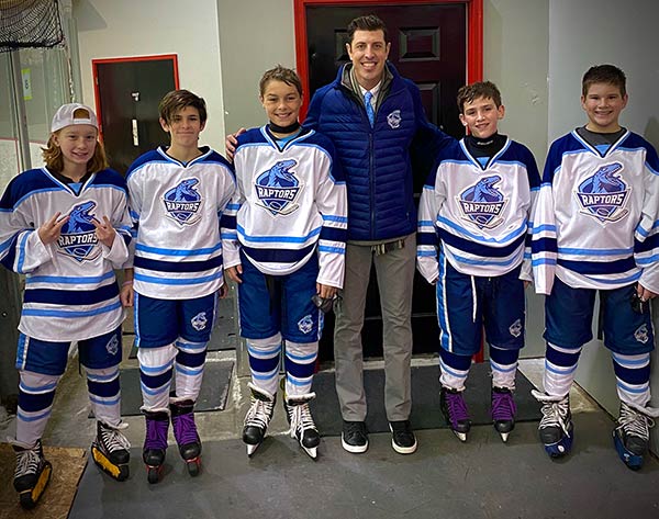 Matt Cross with kids on hockey team in uniform